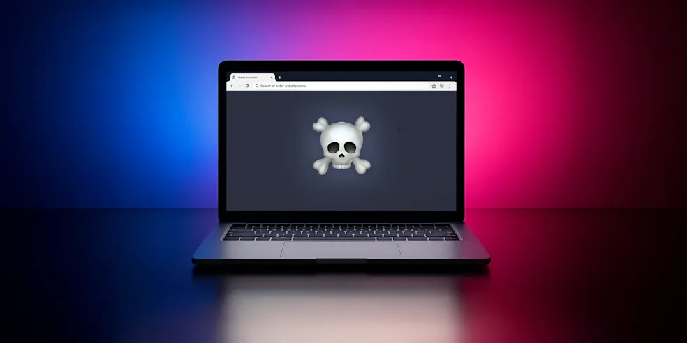 A laptop with a skull emoji on the screen
