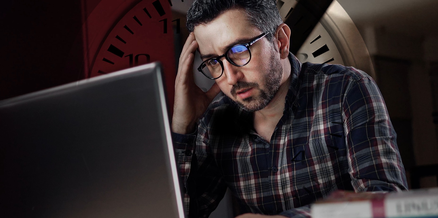 A programmer with a faint clock in the background