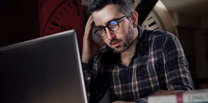 A programmer with a faint clock in the background