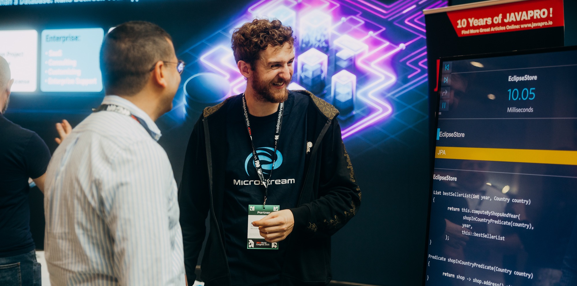 A developer representing a company talking to a conference attendee