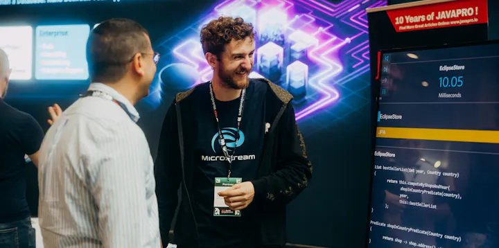 A developer representing a company talking to a conference attendee